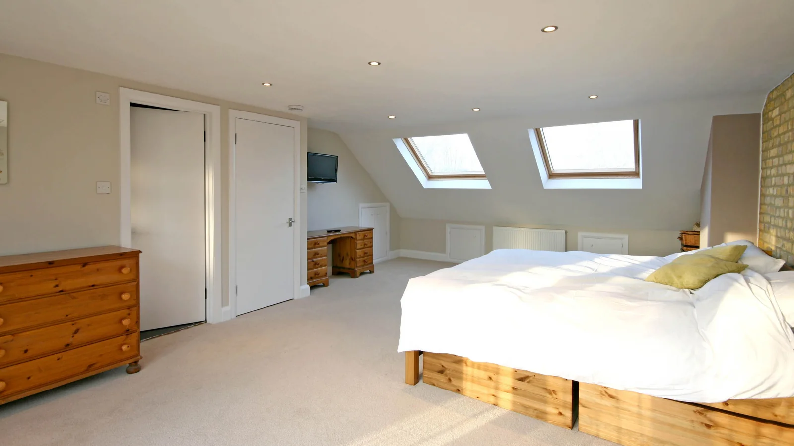 Loft bedroom with roof windows bringing daylight into the converted roof space.